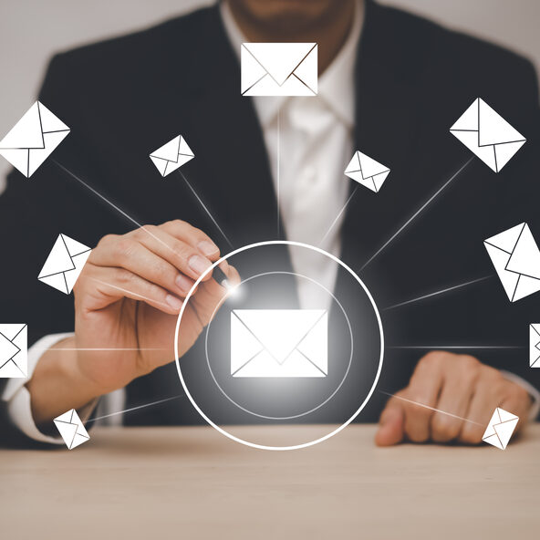 Symbolbild - Mann im Businessanzug, mit einem Touchpen in der Hand und mehrere Briefumschläge in der Luft