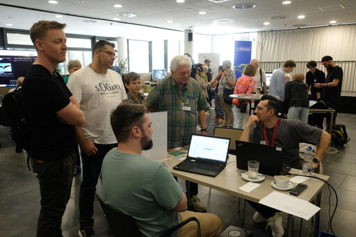 Mehrere Personen stehen um einen Schreibtisch herum