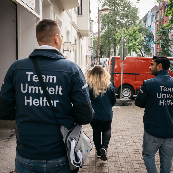 Umwelthelfer der WBD laufen Straße entlang