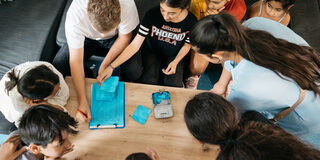 Kinder sitzen um einen Tisch und diskutieren