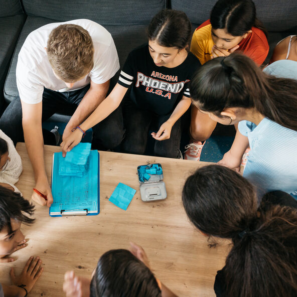Kinder sitzen um einen Tisch und diskutieren