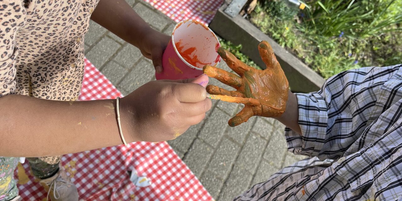 Kinder bemalen Hände mit Farbe