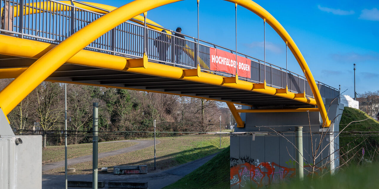 Zwei Menschen spazieren über den fertiggestellten Hochfelder Bogen