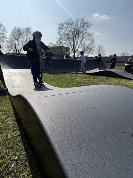 Junge Person die mit dem Cityroller durch den Pumptrack fährt