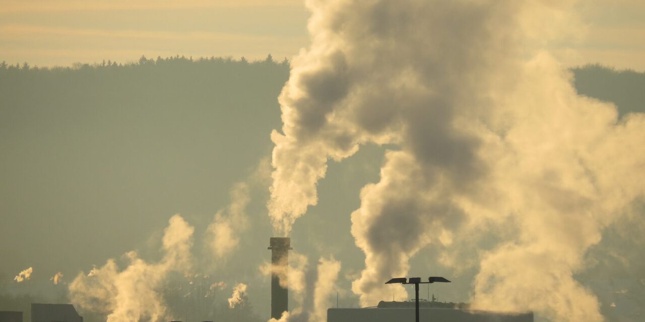 Aufnahme von einem Industrieschornstein aus dem Rauch aufsteigt