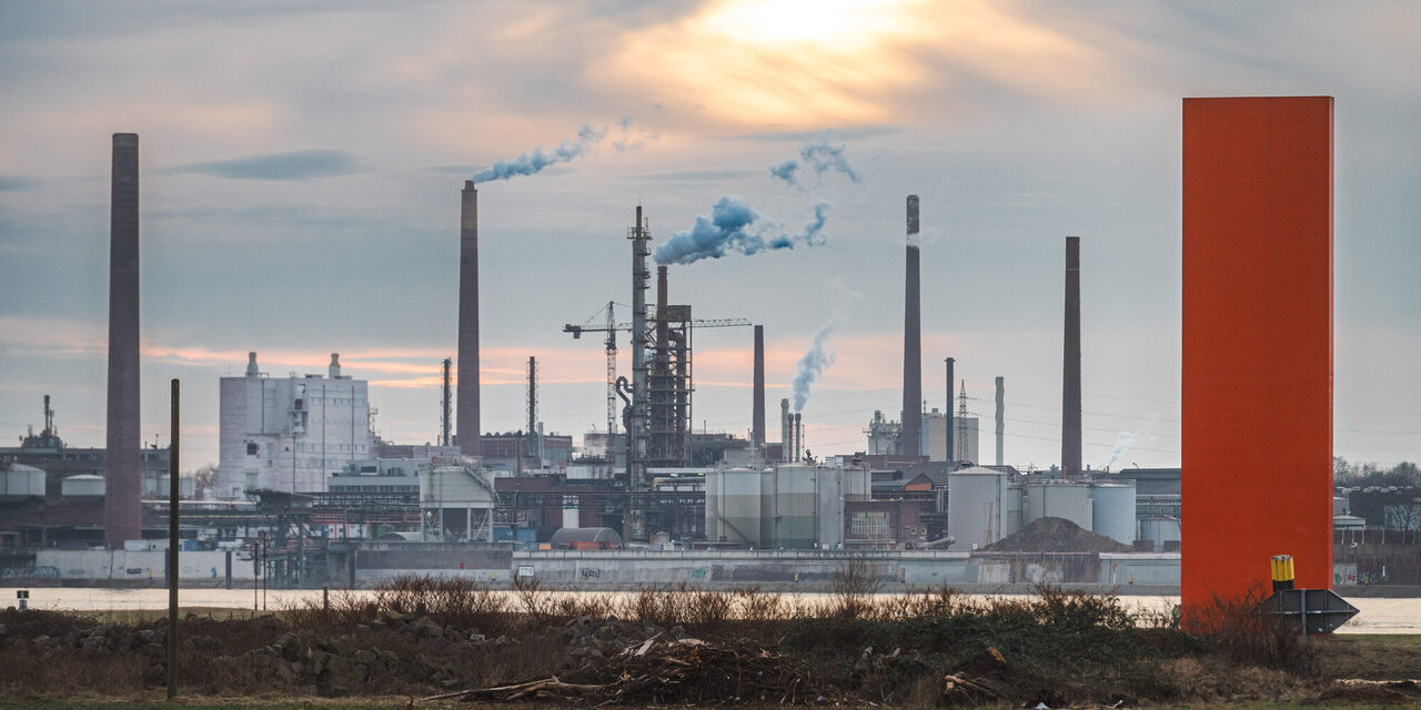 Industriekulisse hinter der Skulptur Rhein-Orange in Duisburg