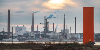 Industriekulisse hinter der Skulptur Rhein-Orange in Duisburg