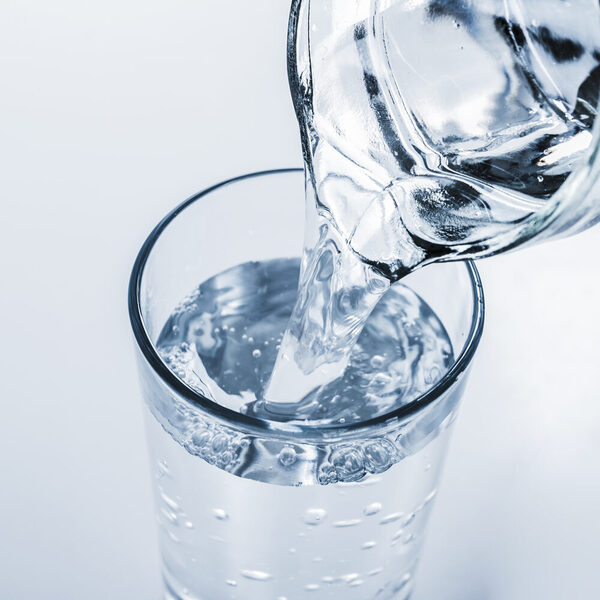 Es wird ein Glas Wasser eingeschüttet