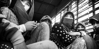 Schwarz-weiß Bild von fünf Frauen, die alle eine Kopfbedeckung tragen und teilweise Mund und Nase verdeckt haben
