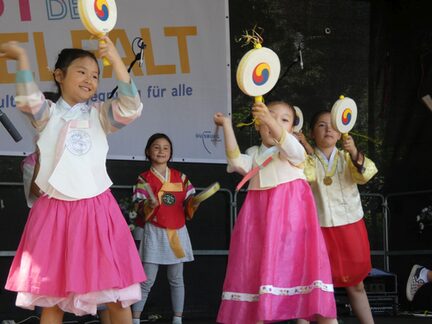 vier Mädchen der Koreanischen Schule Duisburg e.v., die den Hand-Drum Tanz aufführen, gekleidet in traditioneller Kleidung