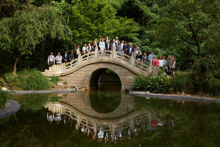 Teilnehmer*innen auf der Bogenbrücke im Chinesischen Garten