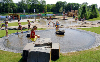 Kinder spielen im Sommer auf dem Wasserspielplatz Wedau