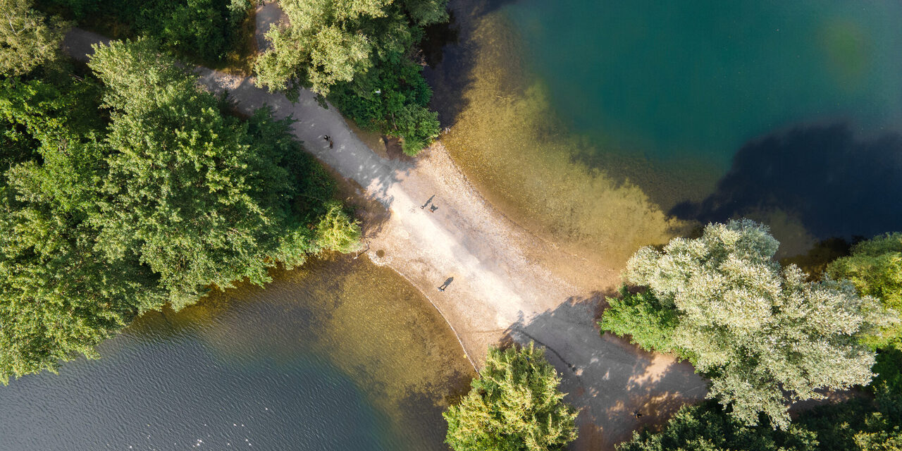 Blick von oben auf einen Weg zwischen zwei Seen.