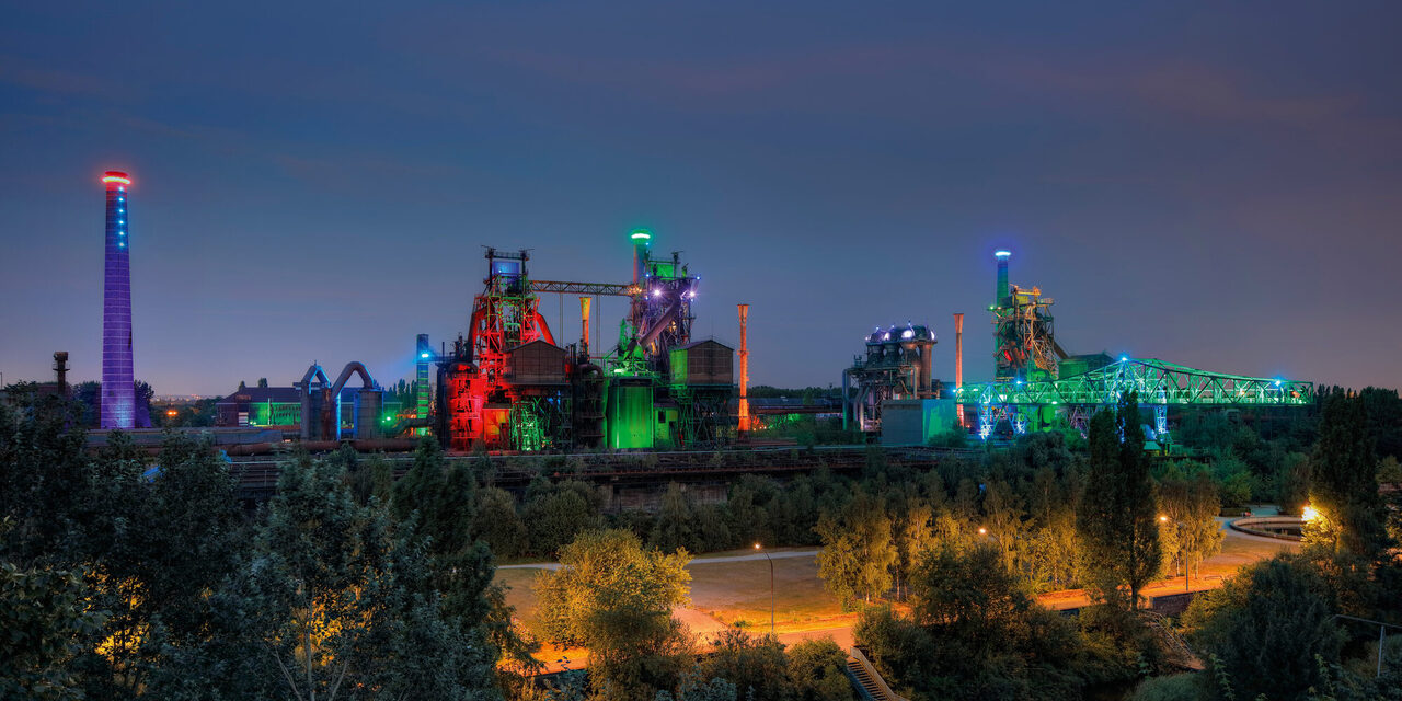 Der Landschaftspark Duisburg-Nord in der Dämmerung bunt illuminiert.