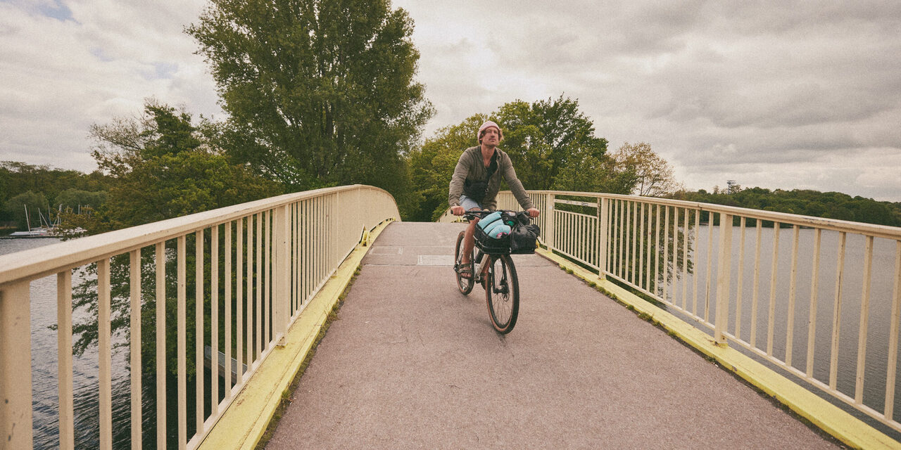 Ein Radfahrer fährt über eine Brücke.