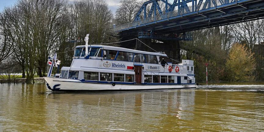 Das Fahrgastschiff Rheinfels fährt unter einer Brücke hindurch.