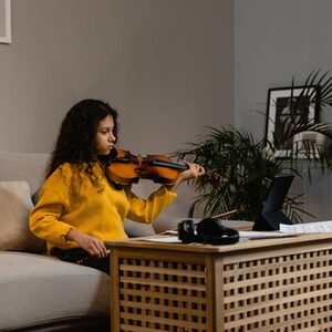 Mädchen auf einem Sofa, das Geige spielt