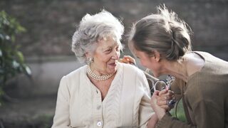 Eine Seniorin unterhält sich mit einer jüngeren Frau