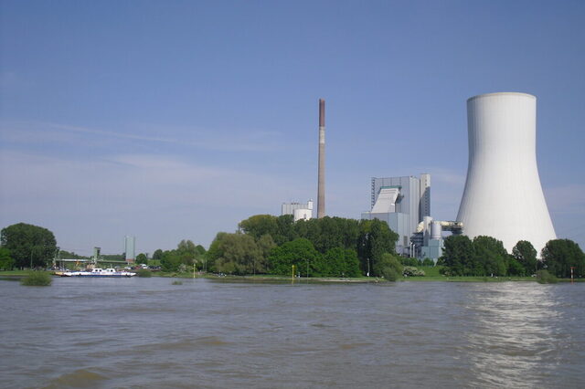 Flusslandschaft mit Kraftwerk und großem Kühlturm.