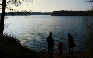 Familie am See in der Dämmerung im Herbst